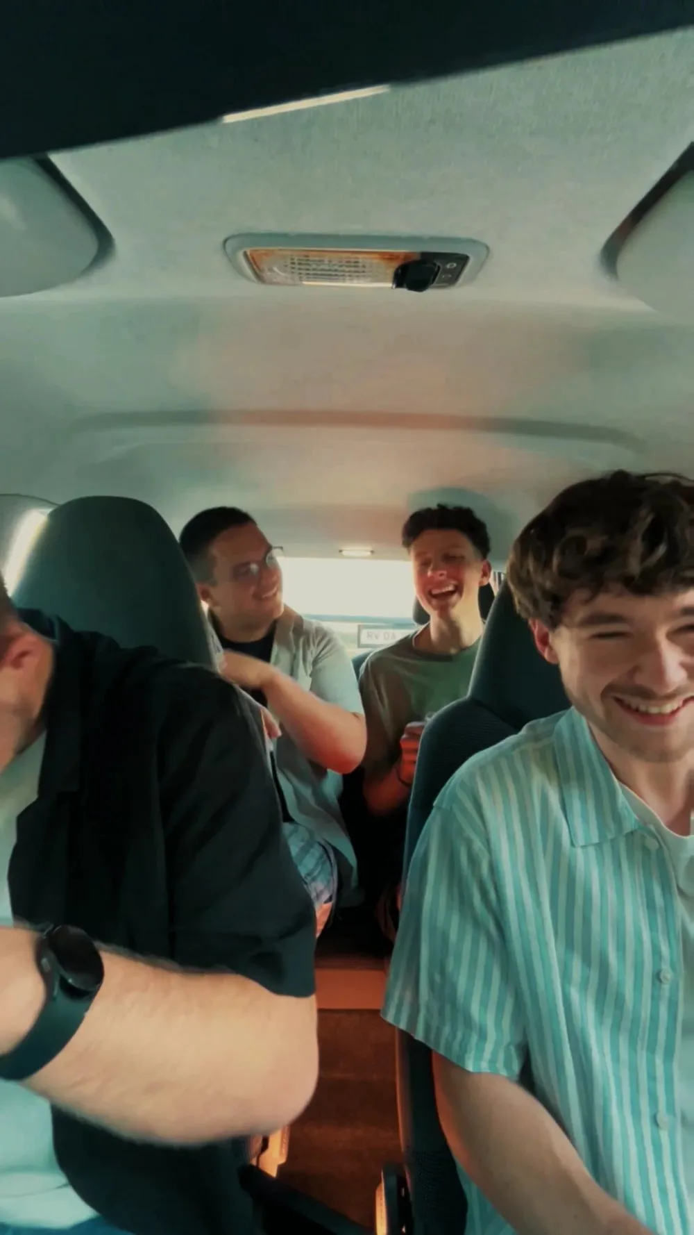 Lukas, Giulio, Manu and friends laughing in a car while listening to the song