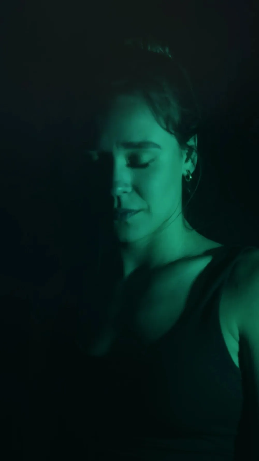 Jessi Woodruff with her eyes closed in green light