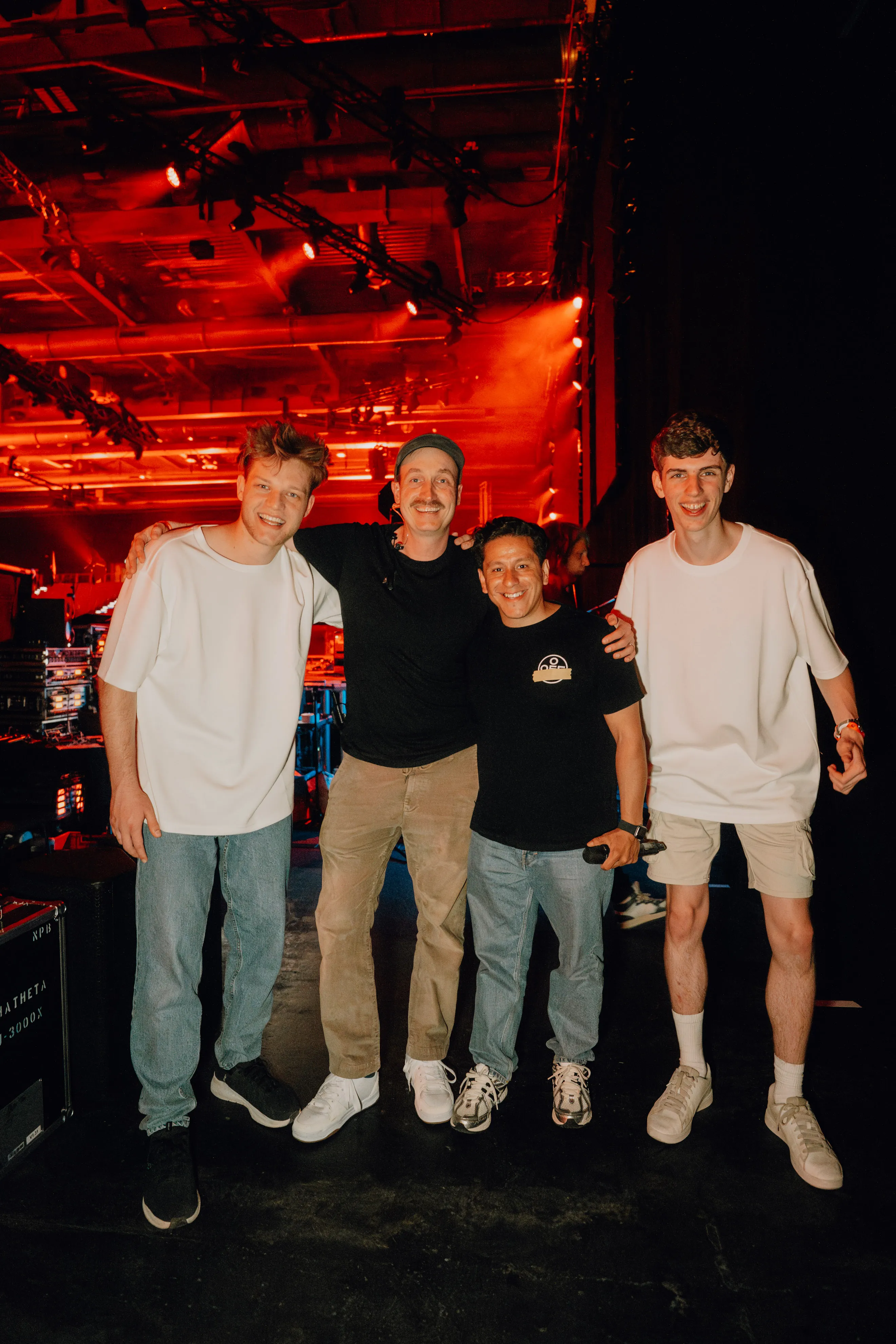 Lukas Goss backstage with three other people under red stage lights at BUJU 2026