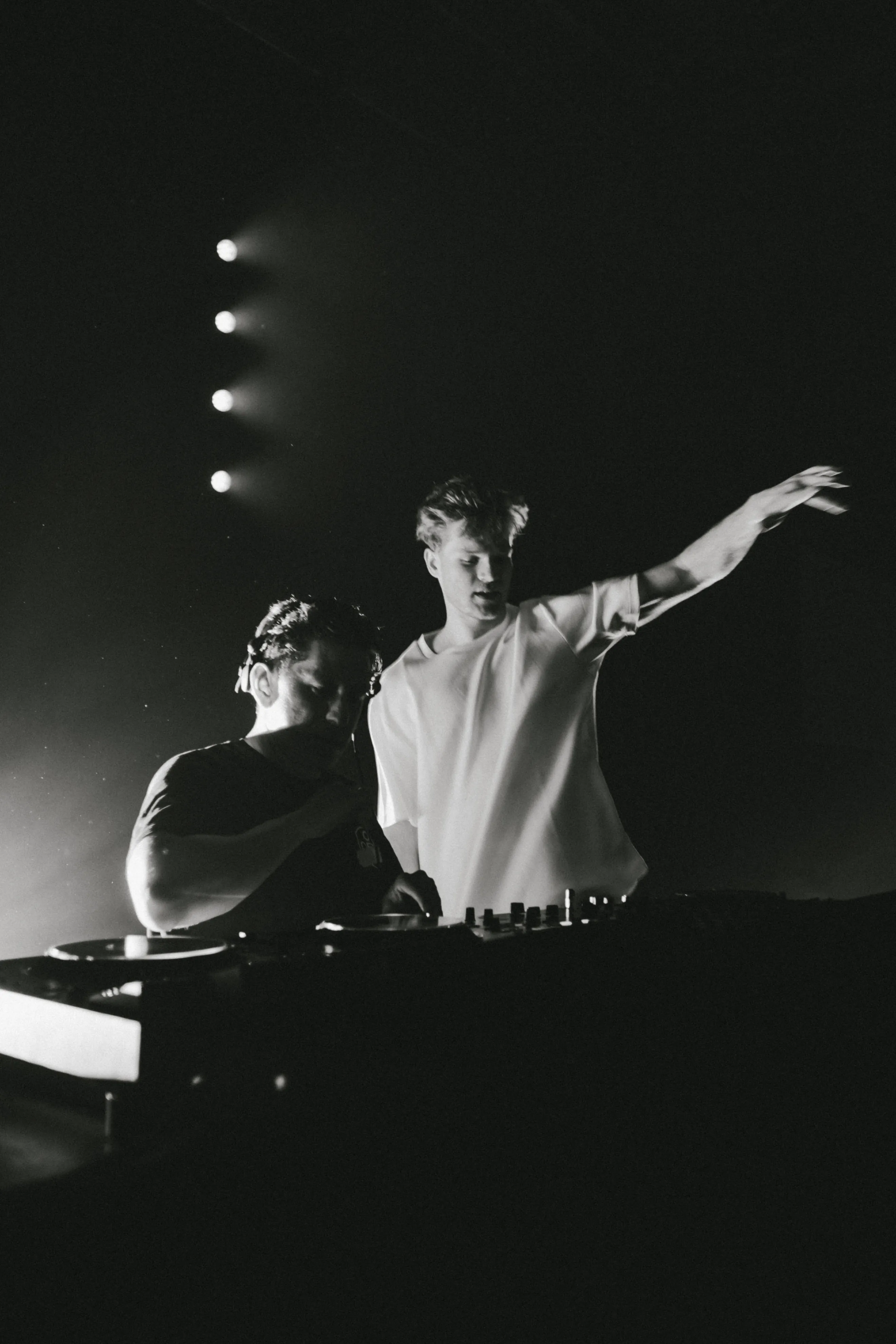 Black and white photo of Lukas Goss gesturing on stage next to DJ Jesus Loves Electro at BUJU 2026