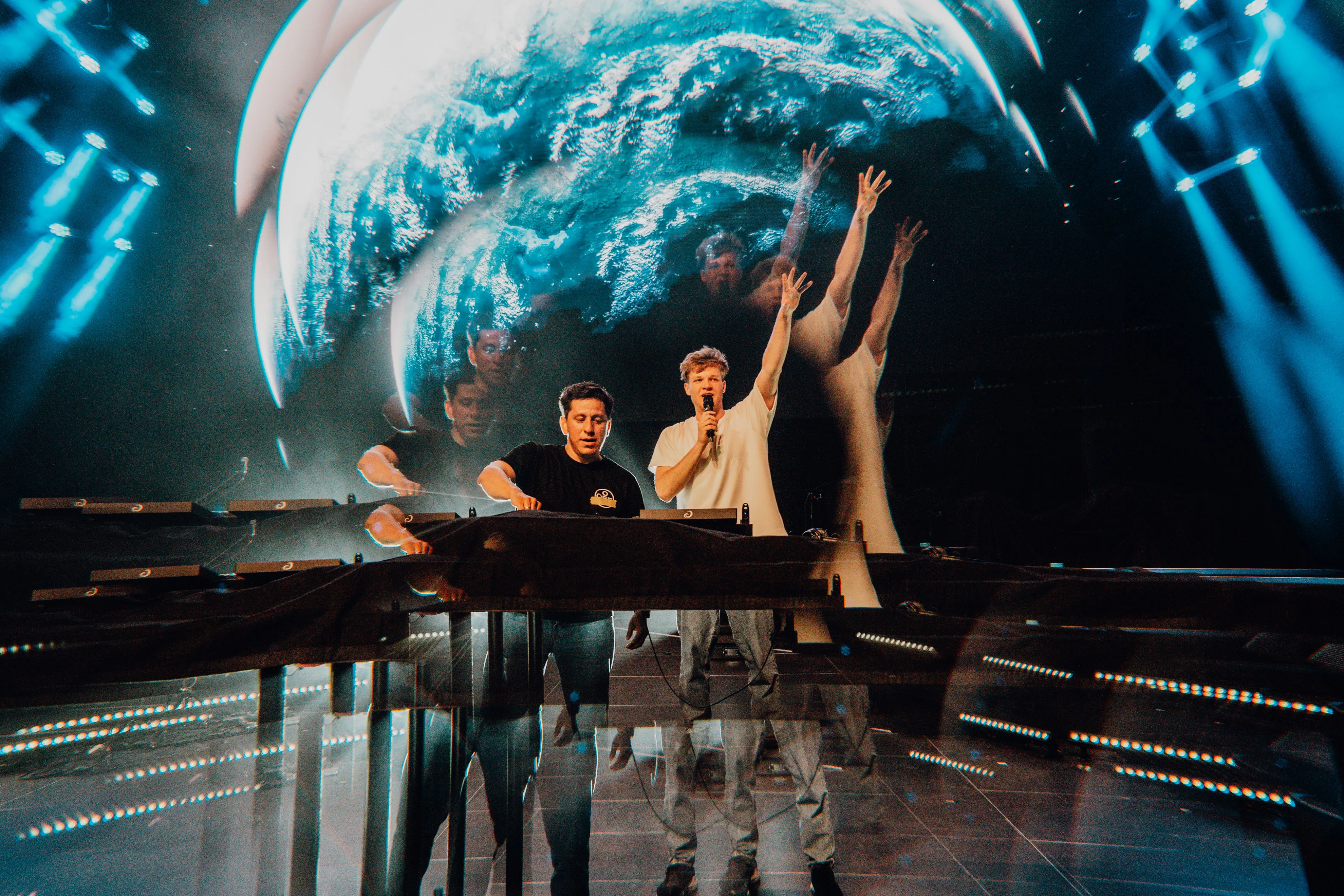 Lukas Goss with a microphone and DJ Jesus Loves Electro at the decks in front of a giant globe on the LED screen at BUJU 2026