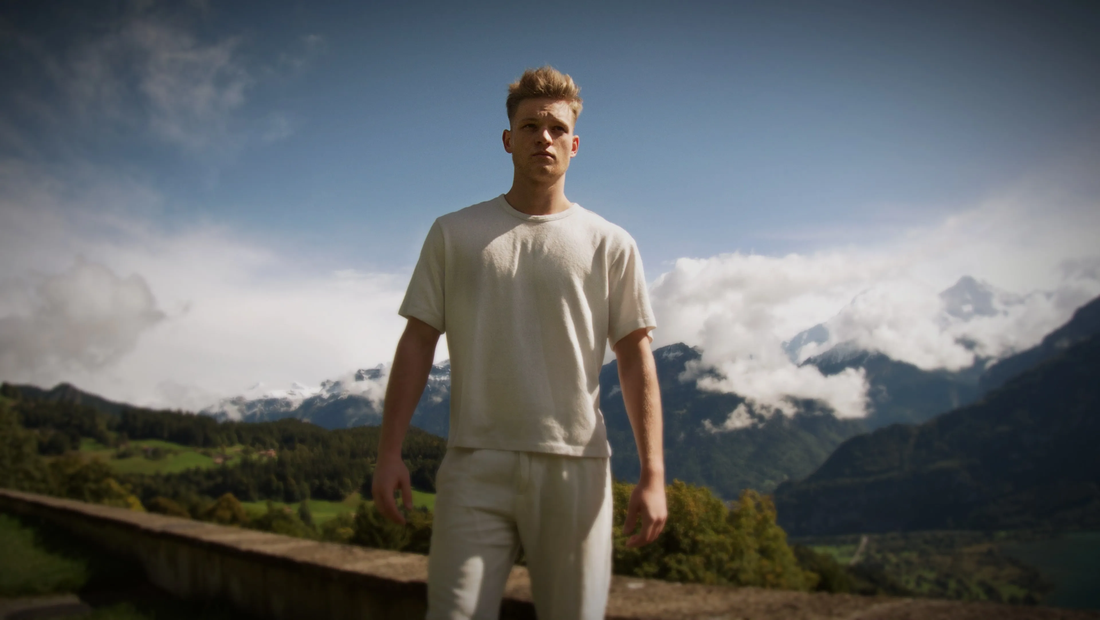 Lukas Goss standing in front of the Swiss Alps