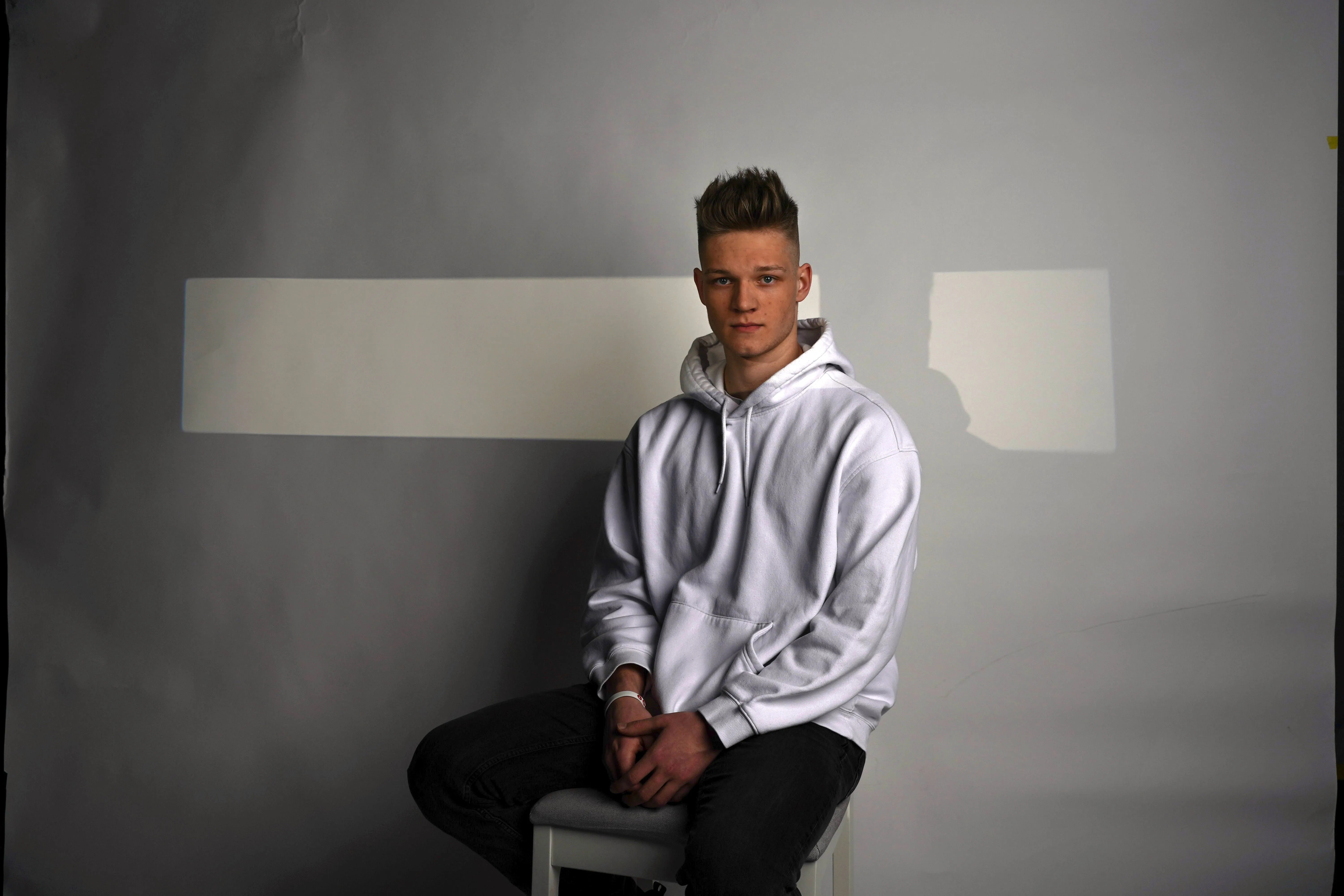 Lukas Goss seated in a photo studio